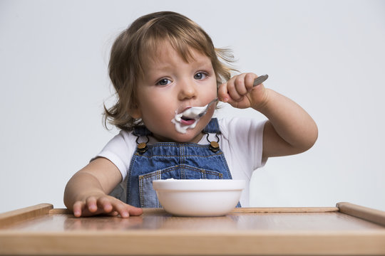 Cute little boy eating porridge