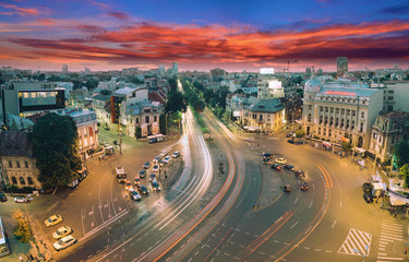 Naklejka premium Beautiful long exposure shot of Piata Romana in Bucharest, Romania. Panorama of traffic, street and a starry night.