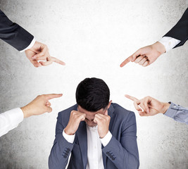 Four people are blaming a stressed Asian businessman