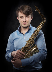 Attractive saxophonist on a dark background.