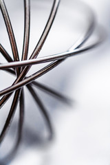 Stainless Steel Egg Whisk. Close up, soft focus.