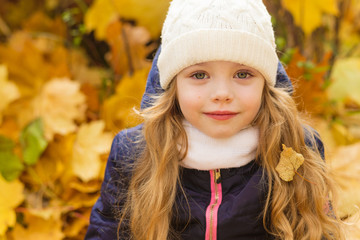 Portrait of a beautiful girl in a blue coat outdoors in autumn