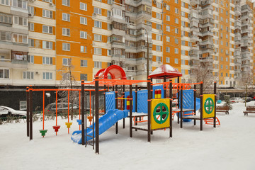 Playground in winter in snowfall