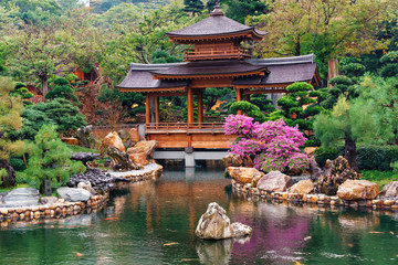 Wooden pagoda by the pond with trout in Nan Lian Garden at Diamond Hill in Hong Kong beautiful scenery