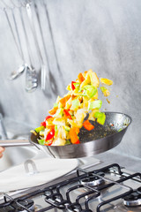 poêlée de légumes qui saute dans une poêle