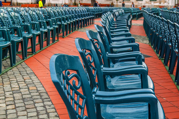 Fototapeta premium Stack of green plastic chair in the city square