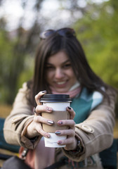 Young beautiful girl with coffee in a paper cup.