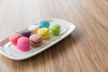 Dessert Macaroon placed in a dish with a wooden background.