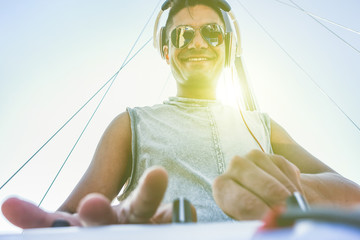 Cheerful dj mixing outdoor in boat party with back lighting 