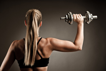 fit woman workout with dumbbells in gym studio photography of a