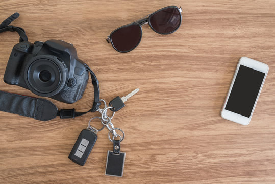 Top view Mobile camera car key glasses on the table.