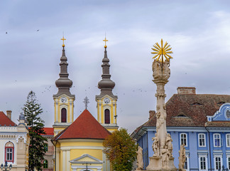 Obraz premium TIMISOARA, ROMANIA - 15 OCTOBER, 2016 Detail of the Holy Trinity Statue at Union square and Serbian Ortodox Church