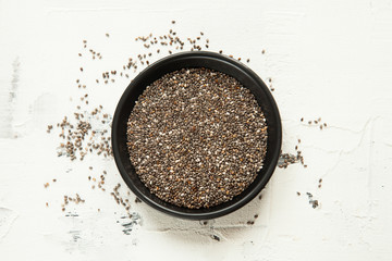 chia grains in a black bowl on a white table