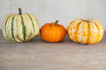 Three gourds on the grey wooden table, selective focus