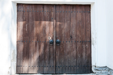 Old wooden door with metallic handles and random shadow casts
