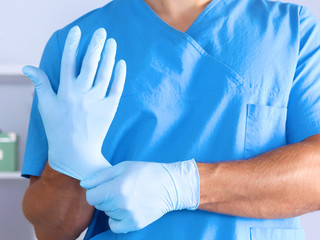 The surgeon wears gloves before surgery. Close-up