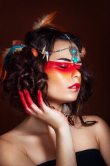 Fototapeta premium Beautiful squaw in ethnic jewelry . Close up portrait. Native american costume. Portrait of a woman with a painted face. Creative makeup and bright style.