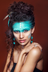 attractive young woman in ethnic jewelry . close up portrait. Beautiful girl shaman. Portrait of a...