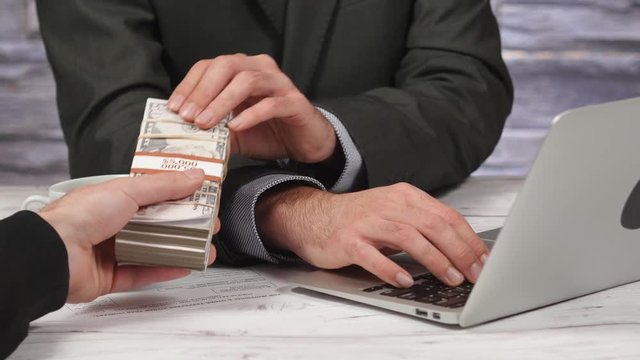 Businessman receiving cash money bribe from a hand. 