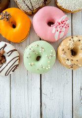 variety of doughnuts on wooden surface