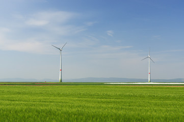 green meadow with Wind turbines generating electricity