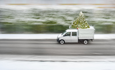 Auto ist am fahren mit Weihnachtsbaum und Schnee am Weihnachten