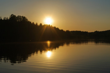 red and orange sunset over lake with water reflection