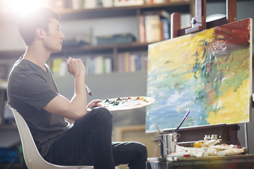 Artist painting in his studio