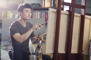 Artist painting in his studio