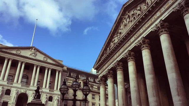Classical architecture in the City of London, the financial center, of the Bank of England and the Royal Exchange in the changing light of timelapse clouds 