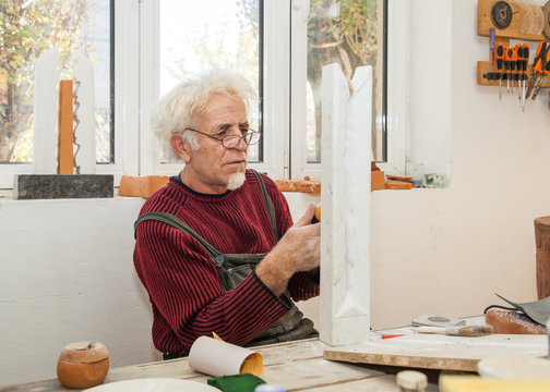 sculptor in his studio handles a piece of marble