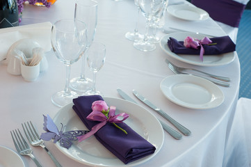 Festive table setting in the restaurant with flowers. Wedding decor.