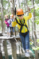 Happy children playing in tree top adventure park