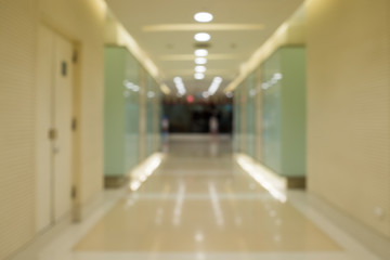 Blurred long corridor in building with doors and reflections. Medical, hospital, office, hotel.
