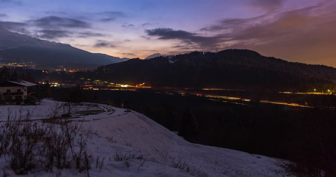 Innsbruck, Austria - view near city of Innsbruck in a valley with Brenner Autobahn and snowy Alps at sunset - Timelapse with zoom out 