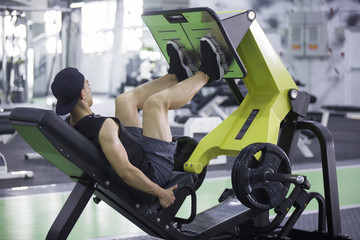 Young man using exercise machine in gym