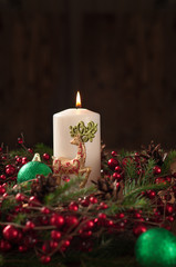 Christmas wreath with white candle, reindeer and ball dark background