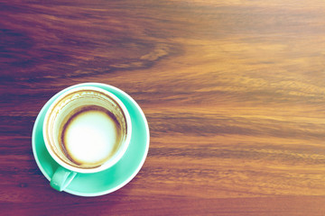 Empty a cup of Latte Coffee art on the wooden desk with vintage filter