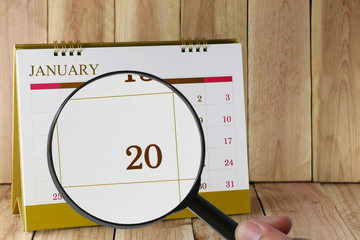 Magnifying glass in hand on calendar you can look Twentieth day