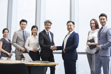 Businessmen shaking hands in meeting room