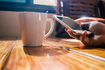 Hand hold smart phone  in the morning coffee time
