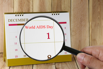 Magnifying glass in hand on calendar you can look text World AID