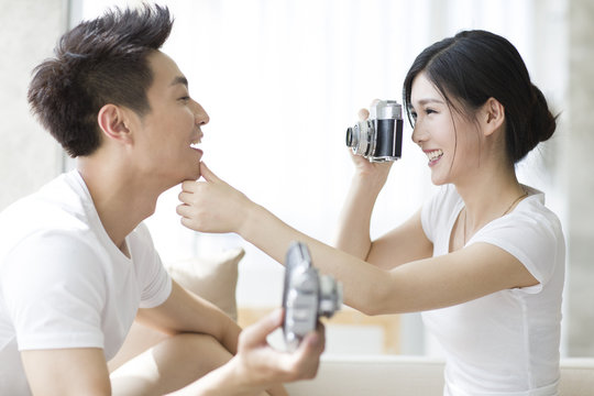 Young couple taking photos at home
