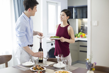Happy young couple setting the table