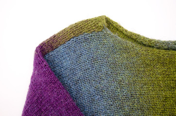 Fototapeta premium Part of handknitted sweater colored wool yarn on white background