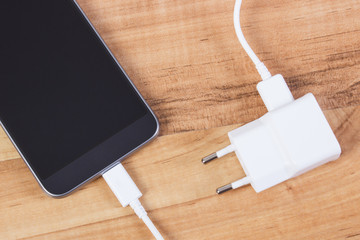 Mobile phone with connected plug of charger, smartphone charging