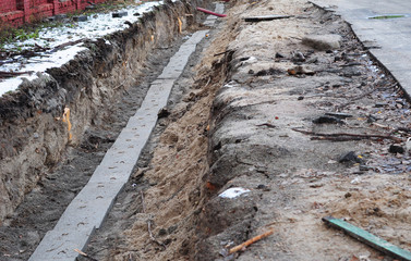 Electric and internet cables, optical fibres in the digging on the street construction site