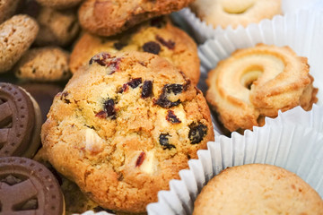Cookies in a box - Chocolate cookies, butter cookies, oatmeal and raisin cookies. Selective focus on the raisin cookie