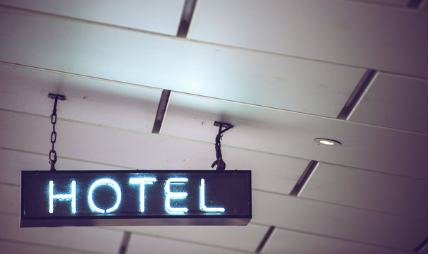 Close up crop neon blue light sign hanging on ceiling and indica