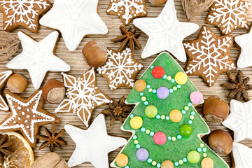 wooden board with christmas homemade gingerbread cookies, fruits and nuts top view